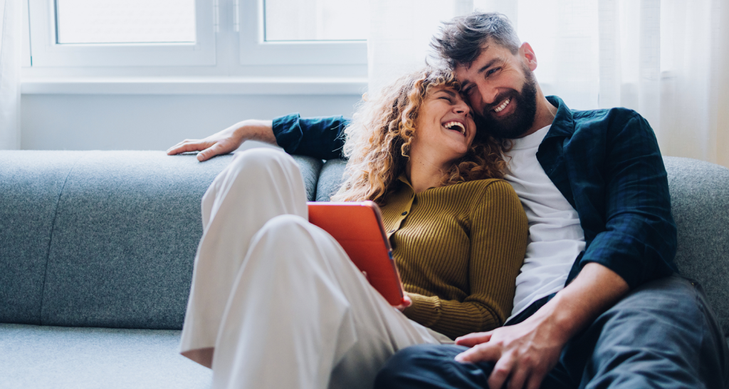 a man and woman cuddling on a couch